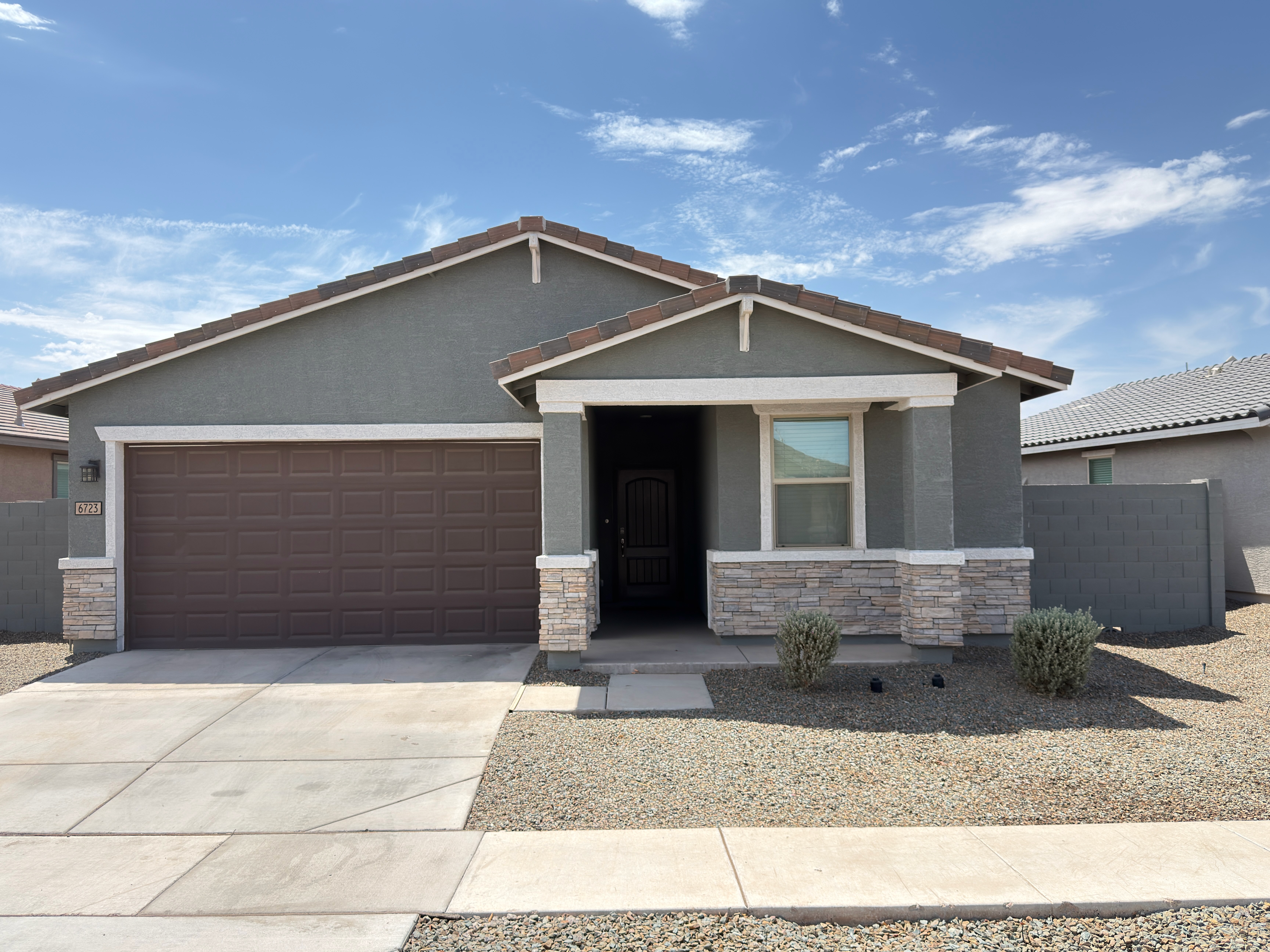 Residential house exterior before painting with red shutters and garage door