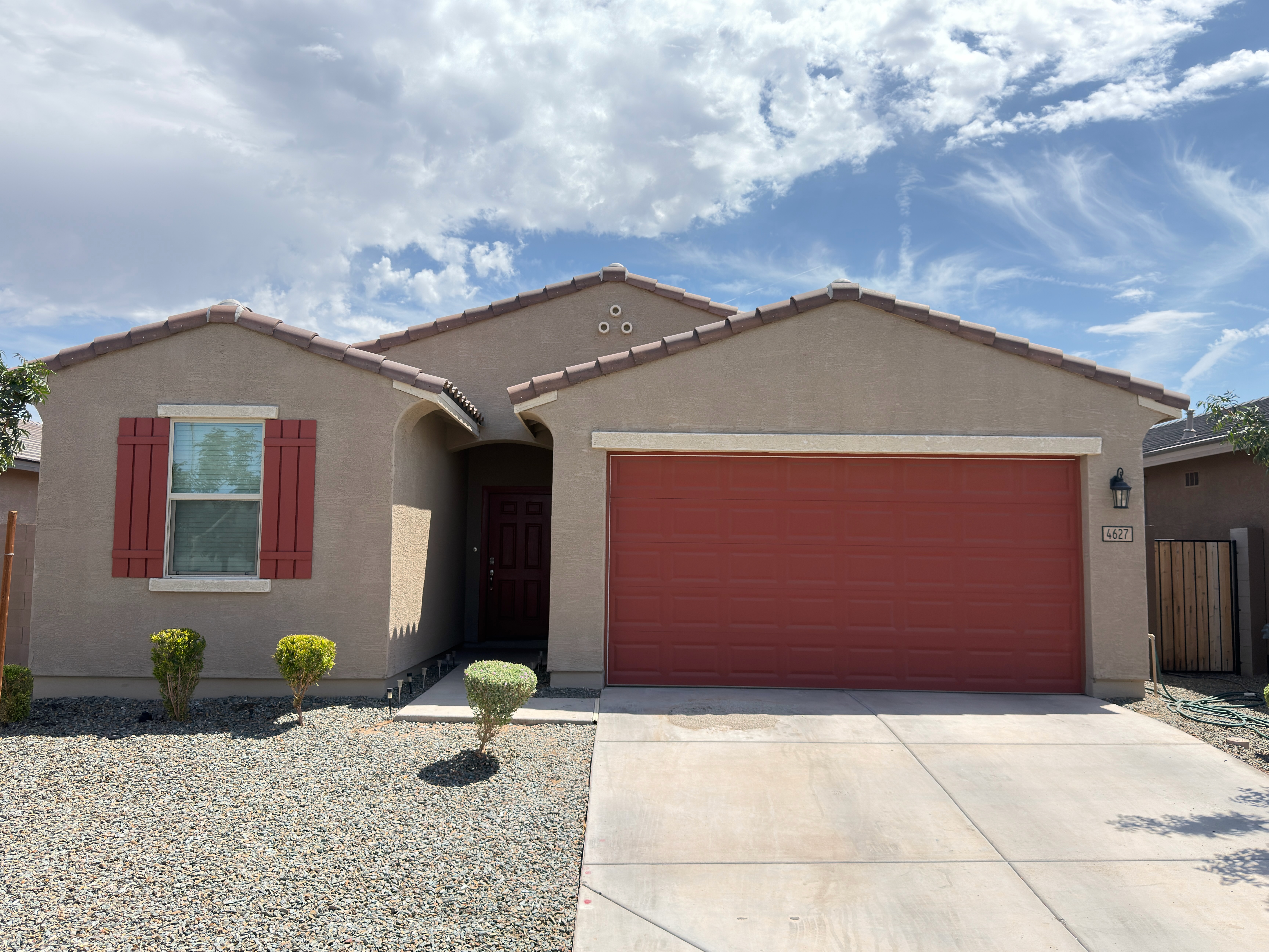 Residential house exterior after taupe paint with garage and shutters